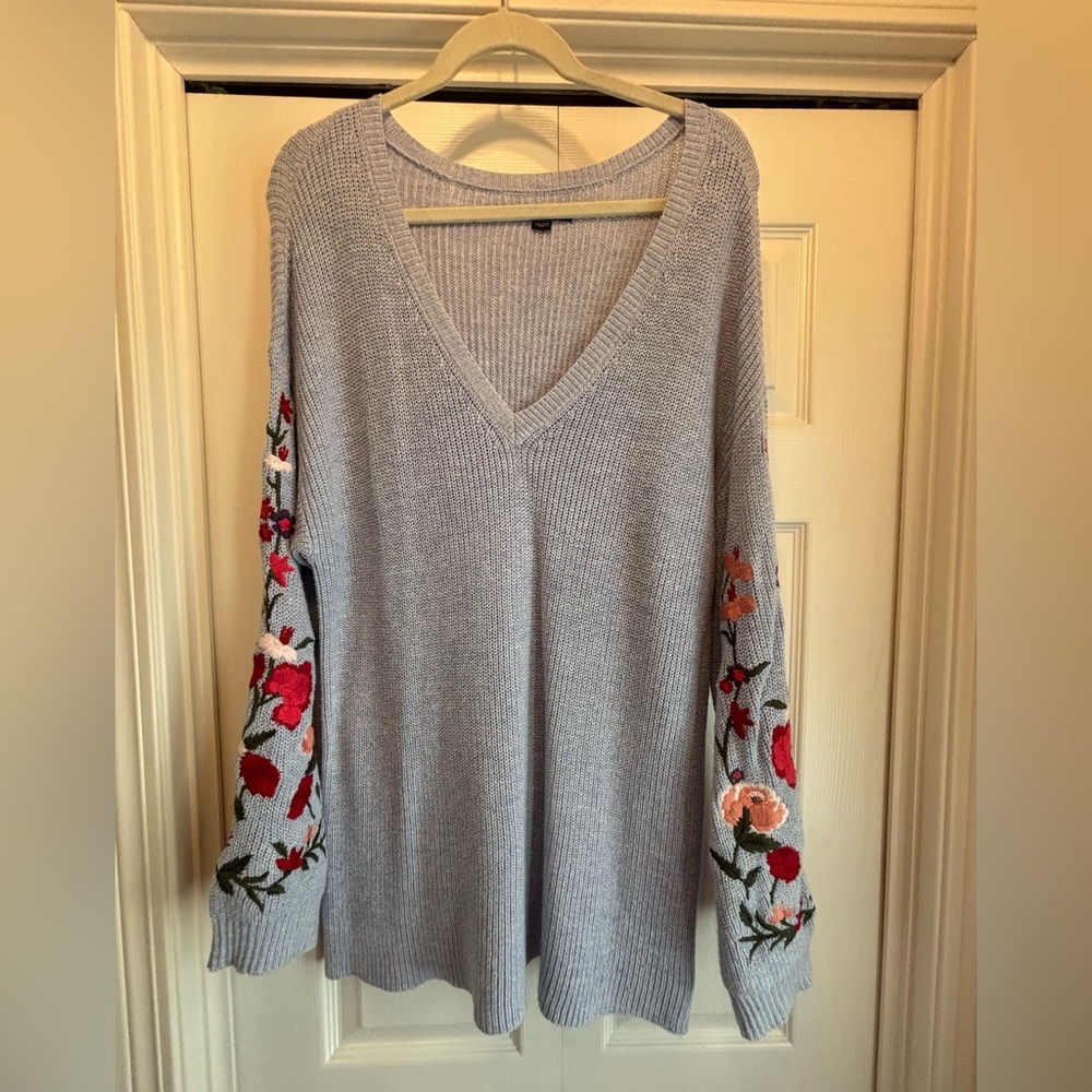 Embroidered blue V-neck sweater.